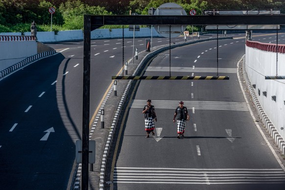 March 22, 2023, Badung, Bali, Indonesia: Two Bali traditional security guards, locally known as Pecalang, patrol around the underpass in Tuban village which temporarily closed on the day of Nyepi. Bal ...