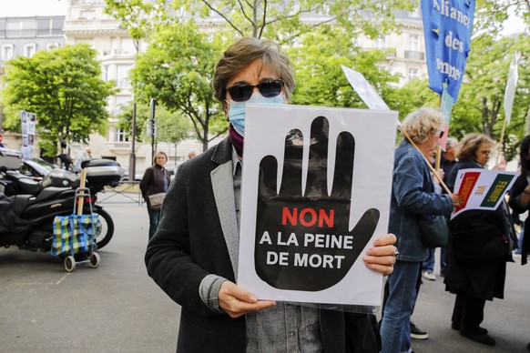 epa10648569 A woman holds a banner with the slogan &quot;No to death penalty&quot; during a demonstration near the Iranian embassy in Paris, France, 23 May 2023. Civil society groups and human rights  ...
