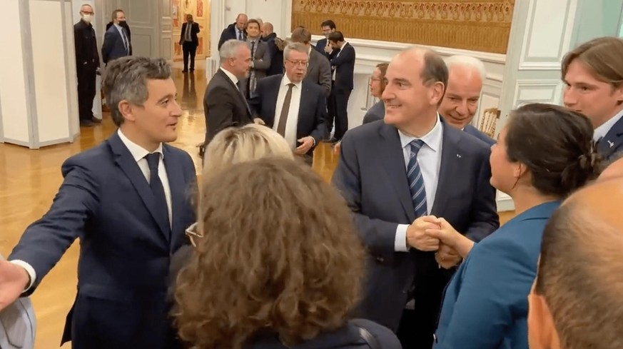 Le premier ministre en train de serrer des mains, sans masque, lors d'un événement officiel.