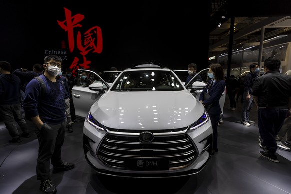 epa09148985 Visitors look at cars on display at the BYD trade fair stand during the first day of the Auto Shanghai 2021 motor show in Shanghai, China, 21 April 2021. The 19th International Automobile  ...
