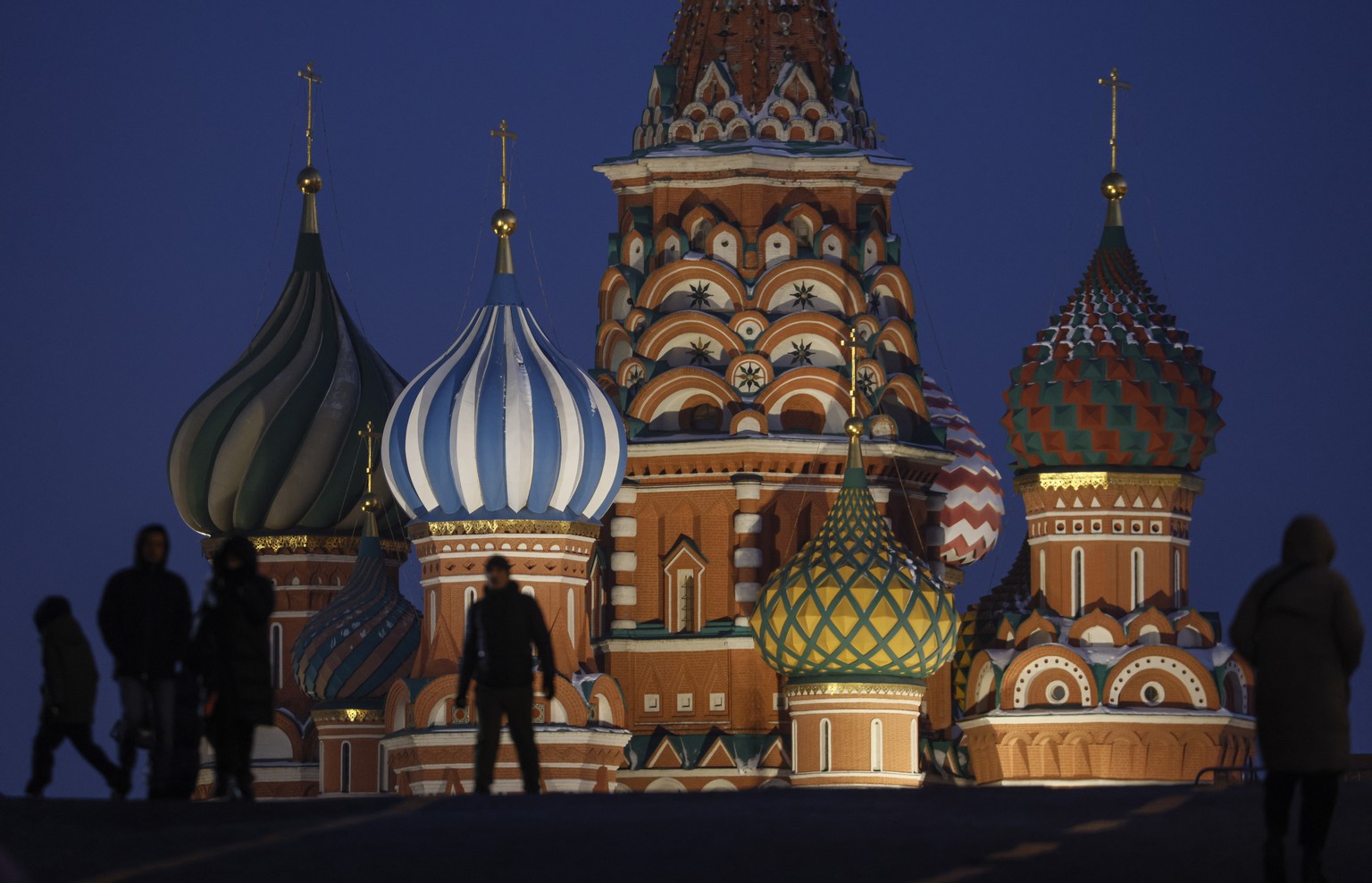 epa10336893 People walk in front of the St. Basil's Cathedral with illuminations for Christmas and the New Year on Red Square in Moscow, Russia, 29 November 2022. Russians are preparing to celebrate N ...