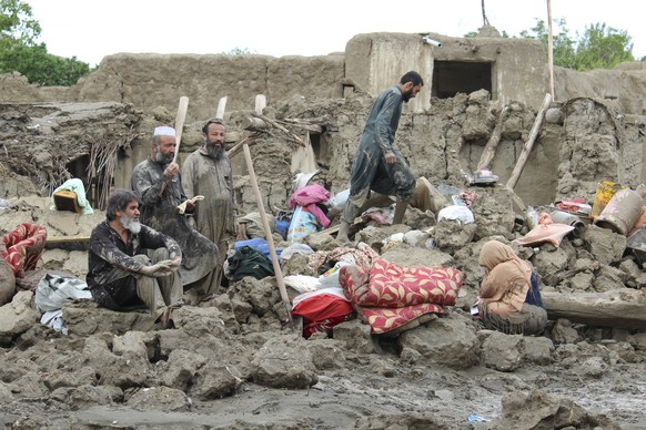 People collect their belongings from their damaged homes after heavy flooding in the Khushi district of Logar province south of Kabul, Afghanistan, Sunday, Aug. 21, 2022. (AP Photo/Shafiullah Zwak)