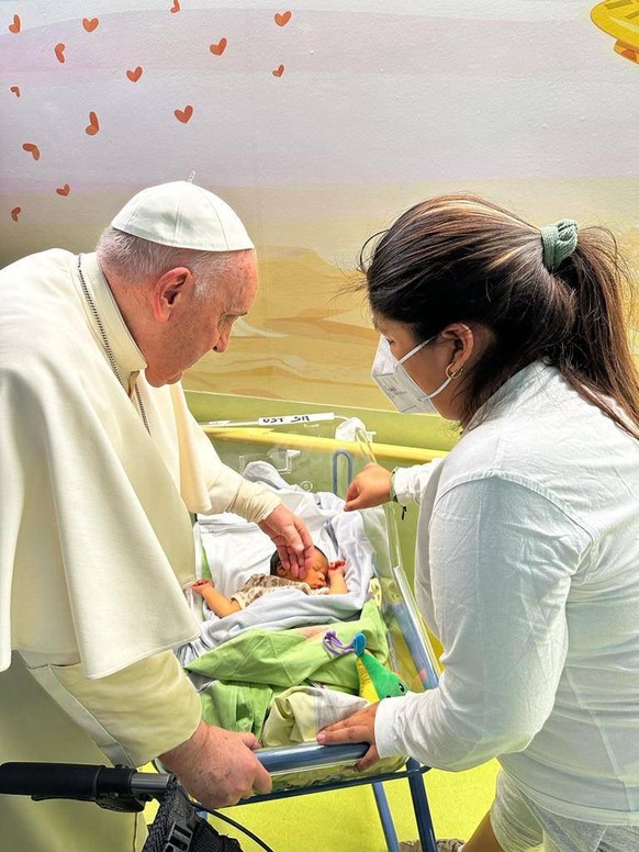 In this image made available by Vatican Media, Pope Francis caresses an infant before baptising him with the name of Miguel Angel, Friday, March 31, 2023 inside the Agostino Gemelli University Hospita ...