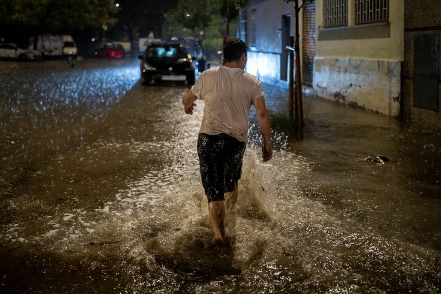 A man walks through a flooded street during heavy rain in L'Hospitalet de Llobregat, on the outskirts of Barcelona, Spain, Sunday, Oct. 4, 2026. (Lorena Sopena/Europa Press via AP) === SPAIN OUT  ...