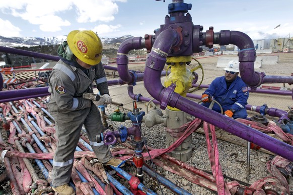 In this March 29, 2013 photo, workers tend to a well head during a hydraulic fracturing operation at an Encana Oil &amp;amp; Gas (USA) Inc. gas well outside Rifle, in western Colorado. The first exper ...