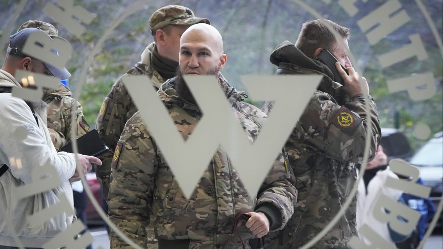 Visitors wearing military camouflage stand at the entrance of the &#039;PMC Wagner Centre&#039;, which is associated with businessman and founder of the Wagner private military group Yevgeny Prigozhin ...