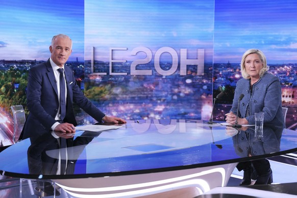 Far-right leader Marine Le Pen poses with television host Gilles Bouleau prior to an interview on the evening news broadcast of French TV channel TF1, after a French court convicted Marine Le Pen of e ...
