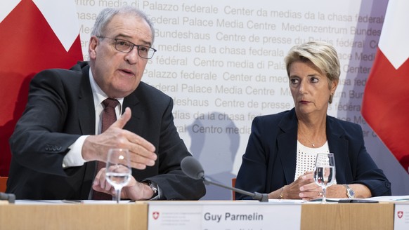 Bundespraesidentin Karin Keller-Sutter, rechts, und Bundesrat Guy Parmelin sprechen an einer Medienkonferenz ueber die Handelsbeziehungen mit den USA, am Donnerstag, 7. August 2025, in Bern. (KEYSTONE ...