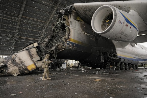 A Ukrainian serviceman walks by the Antonov An-225 Mriya aircraft destroyed during fighting between Russian and Ukrainian forces at the Antonov airport in Hostomel, Ukraine, Saturday, April 2, 2022. A ...