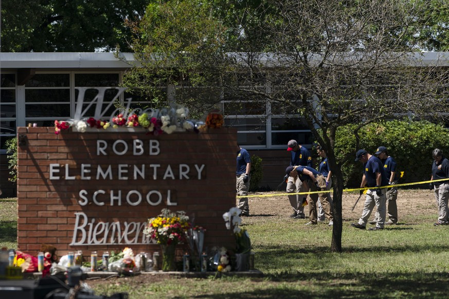 FILE - Investigators search for evidences outside Robb Elementary School in Uvalde, Texas, Wednesday, May 25, 2022. A gunman fatally shot 19 children and two teachers at the school the day before on M ...