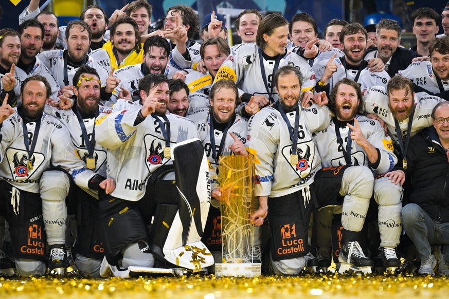 Fribourg um Reto Berra und Julien Sprunger jubeln mit dem Pokal im siebten Eishockey Playoff Finalspiel der National League zwischen HC Davos (HCD) und HC Fribourg-Gotteron (HCFG), am Donnerstag, 30.  ...