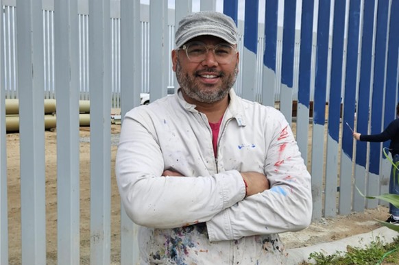 L&#039;artiste Enrique Chiu peint la barrière frontalière américaine.