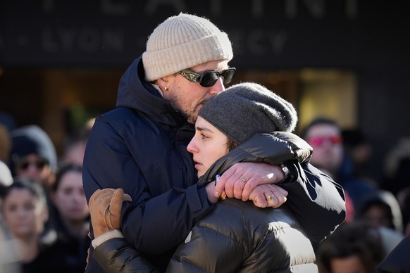 People cry as they attend a memorial procession in Crans-Montana, Swiss Alps, Switzerland, Sunday, Jan. 4, 2026, after a devastating fire in Le Constellation bar left dead and injured during the New Y ...