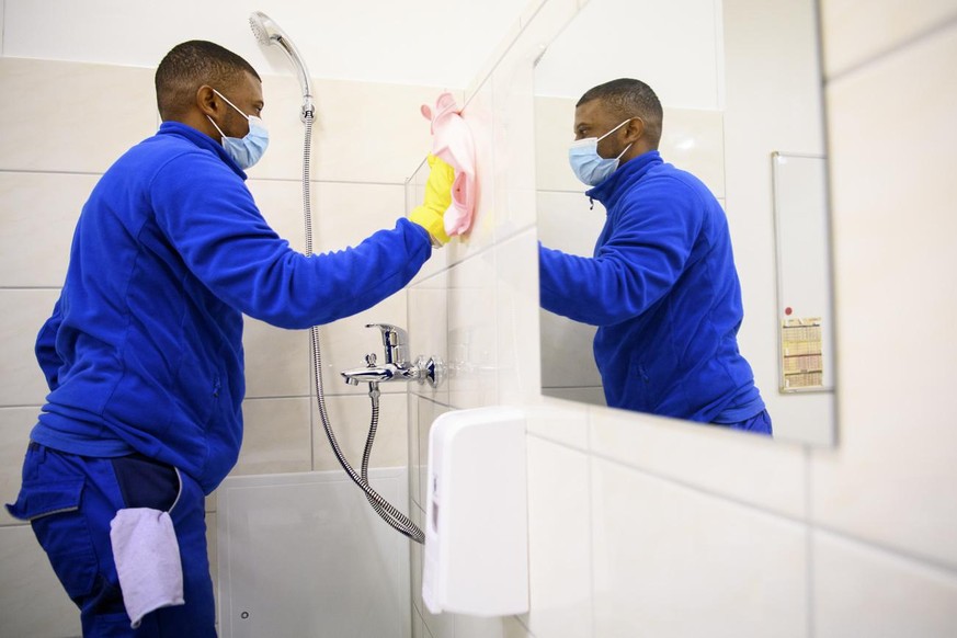 Un requerant d&#039;asile effectue une tache de nettoyage dans une salle de bain lors d&#039;une formation d&#039;emploi au metier d&#039; agent de proprete au centre de formation de l&#039;Etablissem ...