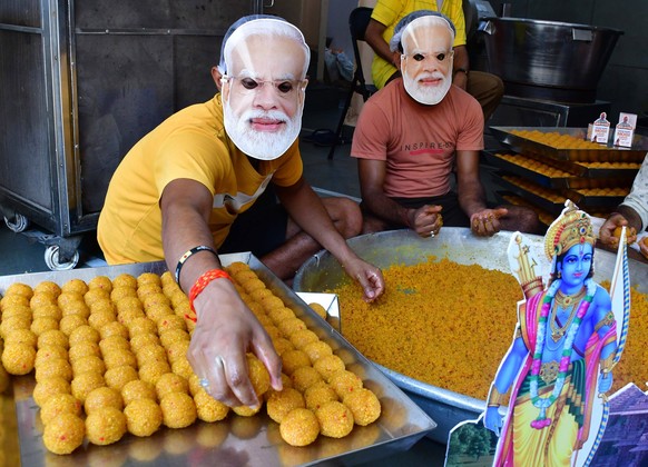 MUMBAI, INDIA - JUNE 3: Workers are seen wearing masks of Prime Minister Narendra Modi as they prepare sweets inside a sweets-making workshop ahead of the Lok Sabha election Poll Results, at Girgaon,  ...