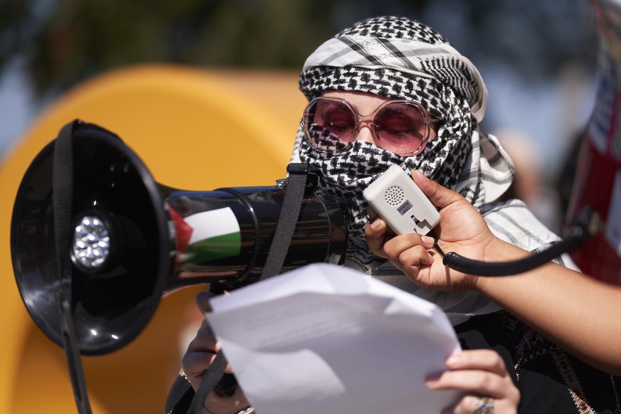 epa10912271 A woman speaks into a megaphone during a demonstration in support of Palestinians at Cal State Long Beach in Long Beach, California, USA, 10 October 2023. The demonstration was organized b ...