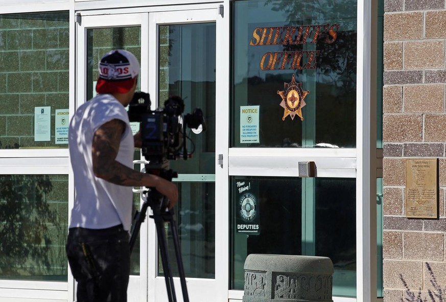 A news cameraman records the entrance of the Santa Fe County Sheriff office in Santa Fe, N.M., Friday, Oct. 22, 2021. Actor Alec Baldwin fired a prop gun on the set of a Western being filmed at the Bo ...