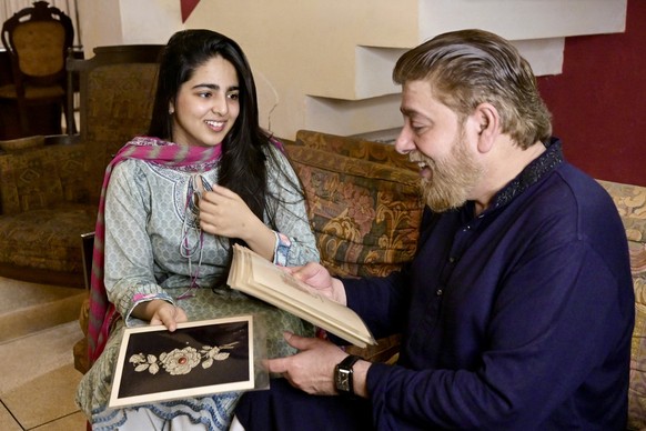 le 18 août 2025, Khawaja Naim Murad (à droite), arrière-petit-fils de Sir Salimullah Bahadur, dernier prince ou nabab de Dhaka, montre des motifs décoratifs alors qu&#039;il est assis à côté de sa fil ...