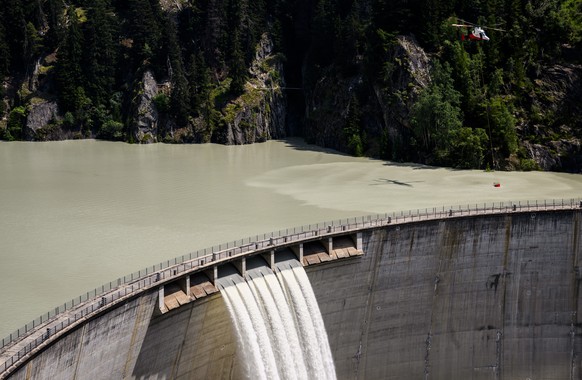 Un helicoptere Rotex, cherche de l&#039;eau dans le barrage Gibidum pour eteindre la foret en feu au-dessus des communes de Bitsch et Ried-Moerel le mardi 18 juillet 2023 au-dessus de Naters. Les h