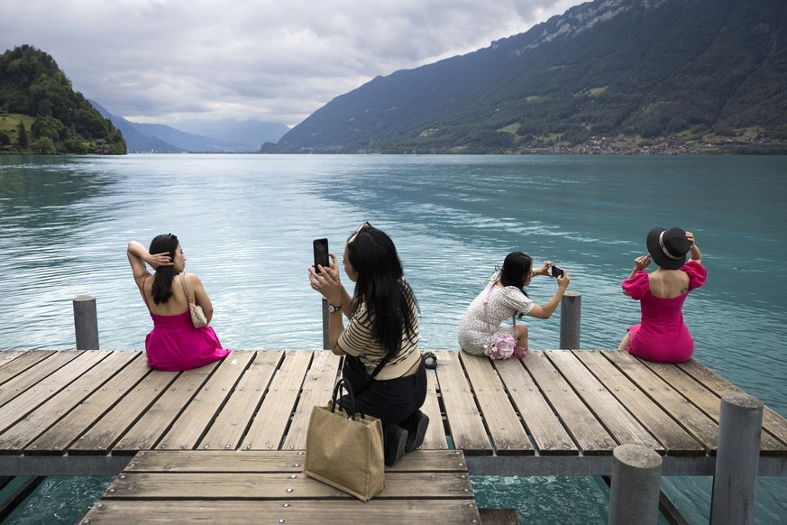 Vietnamese visitors take pictures at the pier in Iseltwald, Switzerland, Tuesday, July 26, 2022. Lots of Asian TV fans and tourists visit the place because the romantic Korean Netflix drama &amp;#039; ...