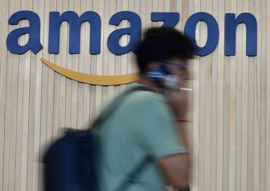 epa12771152 An Employee walks in front of the Amazon logo at the newly inaugurated 'Amazon BLR37' fulfilment office in Bangalore, India, 23 February 2026. The American multinational technolo ...