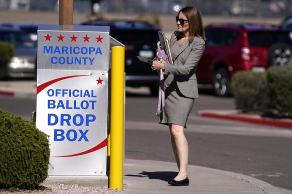 A voter places a ballot in an election voting drop box in Mesa, Ariz., Friday, Oct. 28, 2022. (AP Photo/Ross D. Franklin)