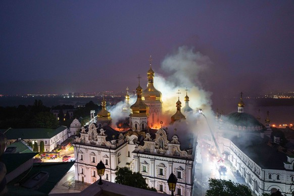Rescue workers try to put out a fire at the Dormition Cathedral of thousand-year-old Monastery of Caves, also known as Kyiv Pechersk Lavra, following a Russian strike on Kyiv, Ukraine, Monday, June 15 ...