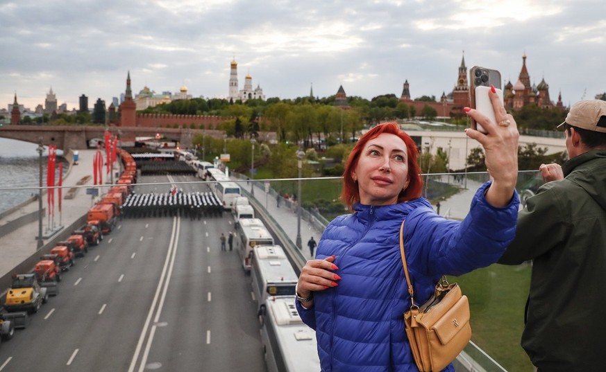 epa10608934 A woman takes a selfie during a rehearsal for the annual military parade ahead of the Victory Day celebrations in Moscow, Russia, 04 May 2023. Russia is preparing to mark the 78th annivers ...