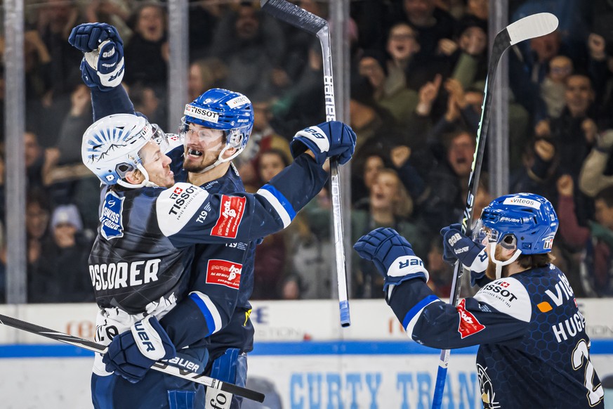 L&#039;attaquant neuchatelois Oliver Achermann, centre, celebre son but avec le topscorer neuchatelois Sondre Olden, gauche, lors de la finale de playoff acte 3 du championnat suisse de hockey sur gla ...