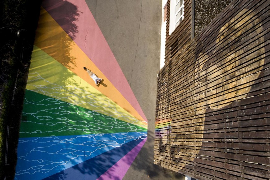 The giant fresco Fluidity of Swiss street artist Antoine Guignard (lying on the ground) aka LPVDA (les pinceaux verts d&#039;Antoine) is pictured during the AILYOS art nature festival, in Leysin, Swit ...