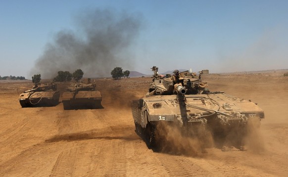 epa03841674 Israeli Merkava tanks perform a manoeuvre in the Golan Heights near the Israeli-Syrian border, 29 August 2013. Israel authorized mobilization of reservists and put its anit-missile batteri ...