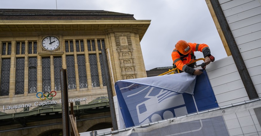 Un ouvrier demonte la palissade sur la place de la Gare CFF lors d&#039;une conference de presse de la ville sur les amenagements provisoires de la place de la Gare le mardi 29 novembre 2022 a Lausann ...