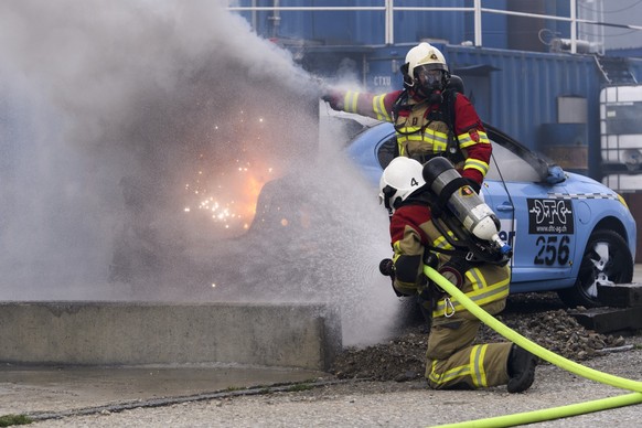 Des pompiers de la ville de Bienne eteignent une voiture electrique en feu lors du Baloise Car Crashtest de vehicules electriques, ce jeudi, 5 avril 2018, au Ausbildungszentrum fuer Sicherheit Afs, a  ...