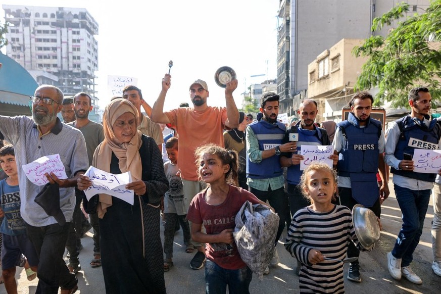 Des manifestants et des journalistes défilent lors d'une manifestation contre la faim dans le quartier Rimal de la ville de Gaza, le 19 juillet.