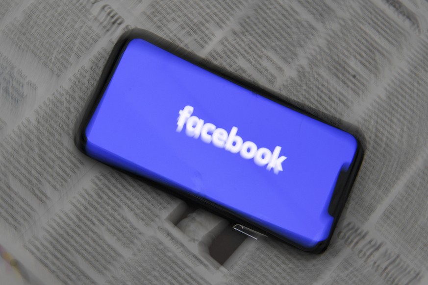 epa09020506 An illustration image shows a phone screen with the Facebook logo and Australian Newspapers at Parliament House in Canberra, Australia, 18 February 2021. Social media giant Facebook has mo ...