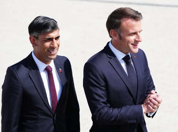 French President Emmanuel Macron with Prime Minister Rishi Sunak arrive for the UK national commemorative event for the 80th anniversary of D-Day, held at the British Normandy Memorial in Ver-sur-Mer, ...