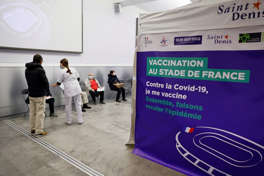 People wait before being vaccinated against COVID-19 at the Stade de France stadium turned as a vaccination center, in Saint-Denis, outside Paris, Tuesday, April 6, 2021. While France remains far behi ...