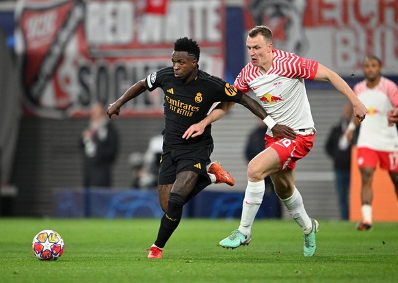 13.02.2024, Sachsen, Leipzig: Fu�ball, Champions League, RB Leipzig - Real Madrid, K.o.-Runde, Achtelfinale, Hinspiele, in der Red Bull Arena. Leipzigs Lukas Klostermann (r) und Reals Vinicius Junior  ...