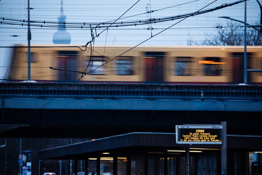 epaselect epa12699776 A display of a tram stop reads 'Strike until Tuesday, 3 AM. U-Bahn, Tram and most Bus services do not run.' while an S-Bahn train of a company that is not affected by t ...