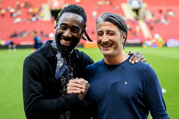 Switzerland&#039;s head coach Murat Yakin, right, talks with former Swiss soccer player and TV consultant for RTS Sport Johan Djourou, left, before the UEFA Nations League group A2 soccer match betwee ...