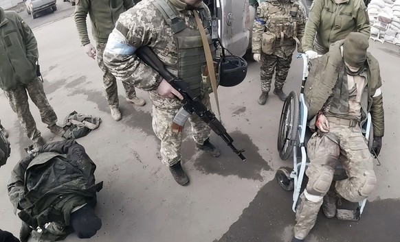 Two injured Russian soldiers, left and right, arrive at a hospital to be treated on March 10, 2022, in Mariupol, Ukraine. &quot;They will not be as kind to us as we&#039;ll be to them,&quot; Yuliia Pa ...