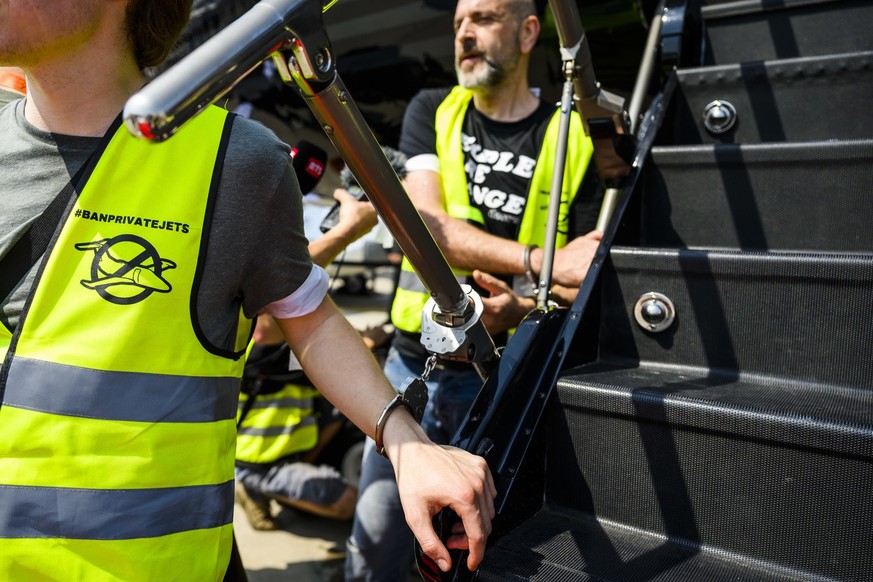 Environmental activists of Stay Grounded and Greenpeace protest by being handcuffed to a aircraft during the European Business Aviation Convention and Exhibition (EBACE), at the Geneve Aeroport in Gen ...