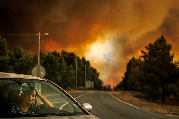 epaselect epa12300562 A woman reacts inside her car during a wildfire in Lamosa, Sernancelhe municipality, Viseu district, Portugal, 14 August 2025. The blaze, which ignited early on 13 August in Sata ...