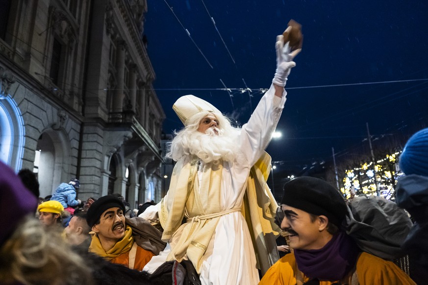 A man disguised as St. Nicolas distributes candy during a procession for the Saint Nicolas prior to delivering his speech from the cathedral St. Nicolas after a procession for the Saint Nicolas in Fri ...