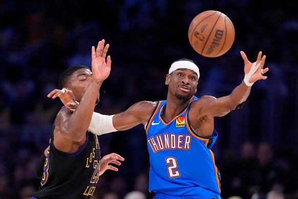 Oklahoma City Thunder guard Shai Gilgeous-Alexander, right, takes a pass while under pressure from Los Angeles Lakers forward Rui Hachimura during the first half of Game 4 in a second-round NBA basket ...