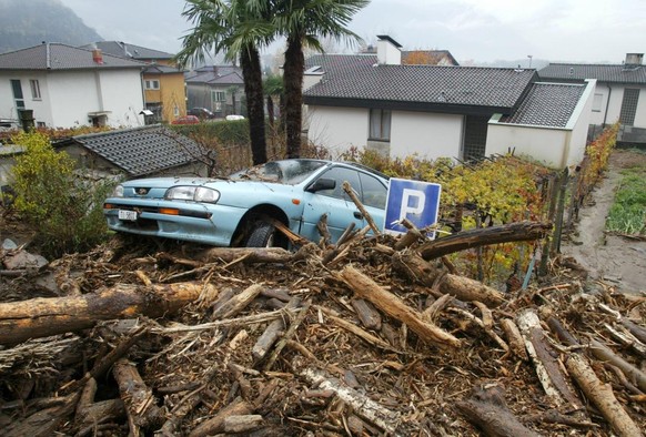 Ein weggerissenes Auto liegt auf einem Berg von Holz, Schlamm und Steinbrocken, am Sonntag, 17. November 2002 , in Bellinzona, wo der ueber die Ufer getretene Wildbach La Guasta groessere Schaeden ang ...
