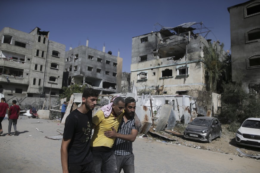 FILE - Palestinians help a wounded man after Israeli strikes in Nuseirat refugee camp, Gaza Strip, on June 8, 2024. The United Nations chief appealed for funding Friday, July 12, 2024, for the beleagu ...