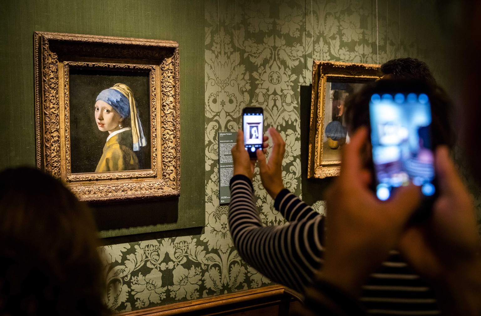 epa10269062 Visitors take photographs of the &#039;Girl with a Pearl Earring&#039; by Dutch artist Johannes Vermeer in the Mauritshuis Museum in The Hague, The Netherlands, 27 October 2022. The Maurit ...