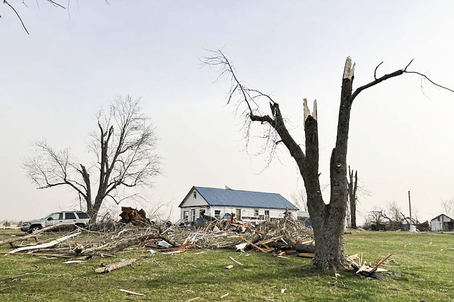 epa11967370 epa11967369 A handout photo made available by the Missouri State Highway Patrol shows a building and tree damaged by a large storm in Howell County, Missouri, USA, 15 March 2025. A large s ...