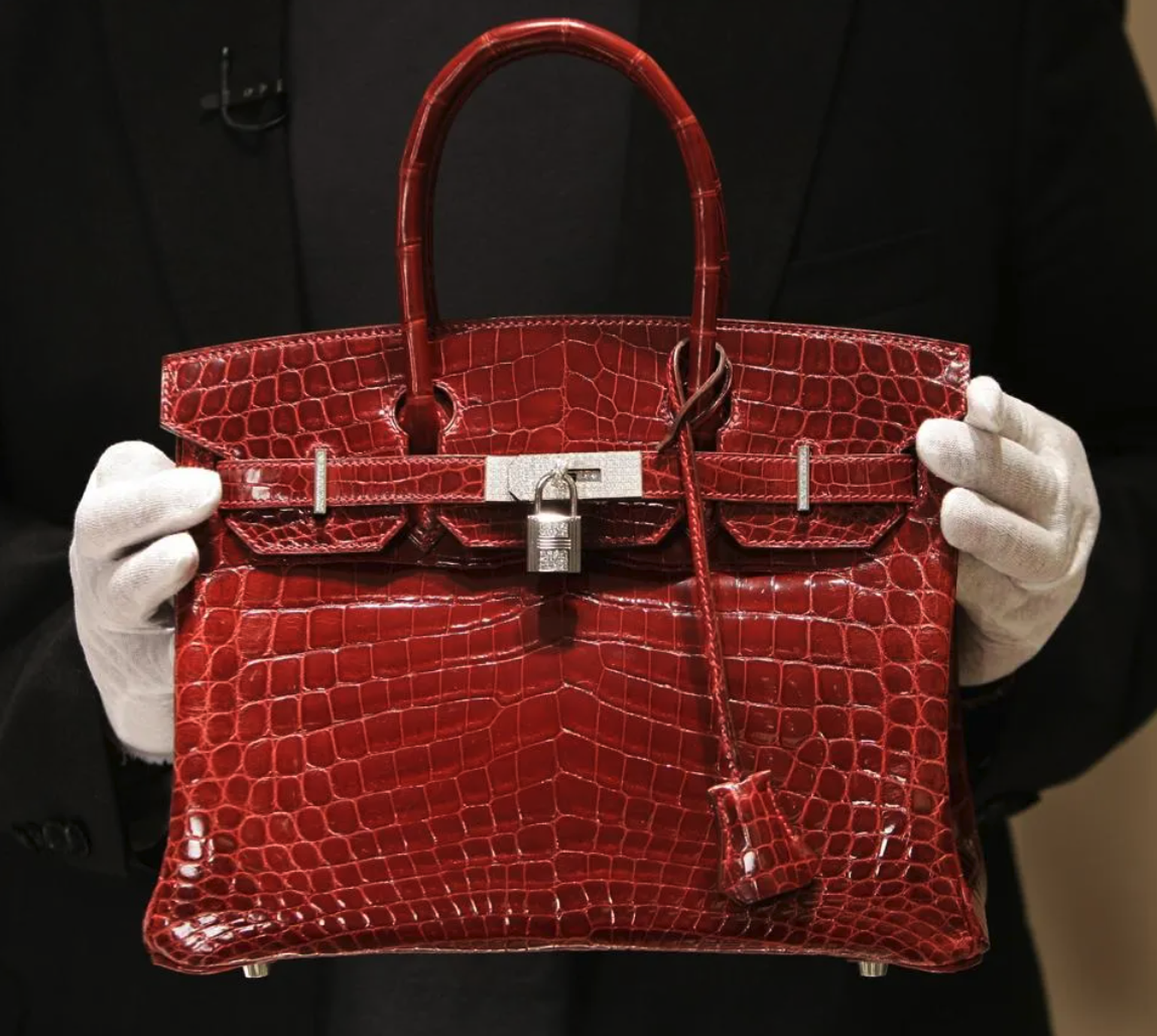 Un employé tient un sac Hermès Birkin en crocodile, d’une valeur de 129 000 dollars, pour le présenter à la presse lors de l’ouverture privée du nouveau magasin Hermès sur Wall Street, à New York, le  ...